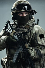 Poster - Male special forces soldier in grey winter uniform. Shot in studio on green background.