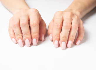 hands of a woman on a white background. Gentle hands with natural manicure, clean skin. Light pink nails.