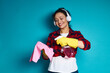 © Taras Grebinets - Young woman with a beautiful smile applying a detergent spray on a rag, cleaning concept shot on blue background
