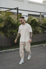 Wall Mural - Vertical shot of a tattooed stylish man walking on the street