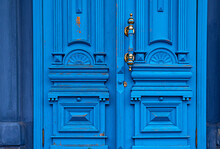 Ornate Door Handle With Old Double Wood Door Painted In Blue. Vintage Wooden Doorway. Classical Architecture Details