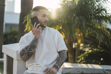 Poster - Handsome European man with tattooed arms talking on the phone