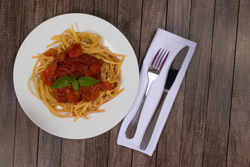 Pasta with rustic tomato sauce and basil leaves. Bavette pasta in red sauce. Top close-up photo with space on the right for text. Fast and tasty food.