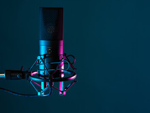 Professional Studio Microphone. Condenser Microphone On A Dark Background. It Is Designed For Podcasting. Microphone As A Symbol For Recording Audio Podcasts. Recording Audio Podcasts In Studio
