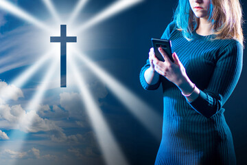 Wall Mural - Catholic cross next to girl. Concept - she is attending church remotely. Remote Catholic Mass App. Catholic woman with smartphone. A girl watches a service on Online. Online Christian Mass