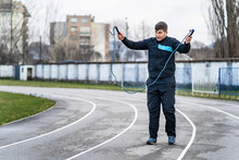 Portrait Of Adult Caucasian Man Male Athlete Standing Outdoor At Stadium Track Hold Jumping Rope In Hand Training - Stamina Skill And Endurance Concept In Spring Or Autumn Day Copy Space Full Length