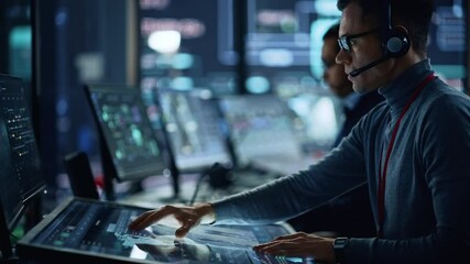 Aufkleber - Portrait of Professional IT Technical Support Specialist Working on Computer in Monitoring Control Room with Digital Screens. Employee Wears Headphones with Mic and Talking on a Call.
