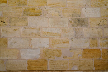 Wall Mural - Fragment of a wall from brown sand chipped stone background