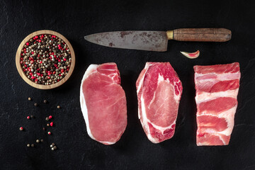 Wall Mural - Pork meat, various cuts, shot from the top with garlic and pepper