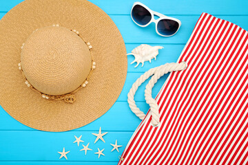 Poster - Summer straw hat with striped bag, sunglasses and seashells on blue wooden table