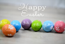 Happy Easter. Easter Eggs On A White Wooden Background. Bright Colorful Easter Egg With Kind And Positive Single Word On It.