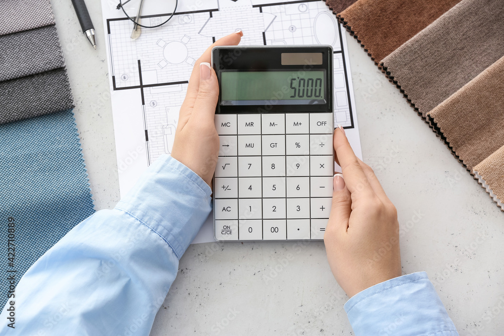 Female interior designer with calculator in office