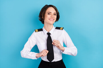 Poster - Photo of charming nice stunning young lady wear tie fix uniform pilot isolated on pastel blue color background