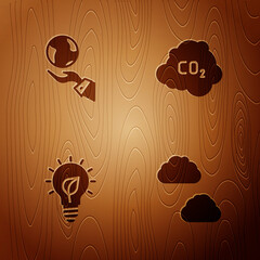 Sticker - Set Cloud, Hands holding Earth globe, Light bulb with leaf and CO2 emissions cloud on wooden background. Vector