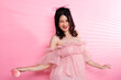 © Jade - Portrait of Asian girl wear pink dress over pink tone background