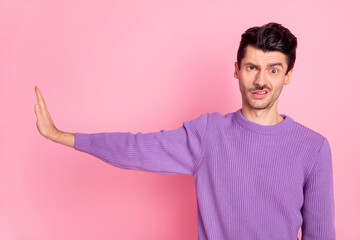 Sticker - Portrait of attractive strict tired guy showing aside stop sign avoid grimace isolated over pink pastel color background