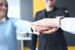 Group of partners folding their hands together in office closeup