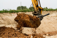 Excavator During Construction New Road In Forest Area. Yellow Backhoe At Groundwork