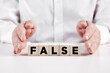 © Cagkan - Businessman hands covers the wooden cubes with the word false. Misleading information