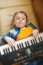 Boy Tired Of Learning To Play The Synthesizer. Little Dreamer Want To Be A Musician.