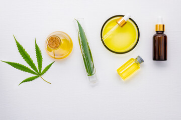 Wall Mural - Glass bottle of cannabis oil and hemp leaves set up  on white background.