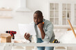 © Prostock-studio - Problems with new furniture assembly. Shocked african american man reading instructions at home