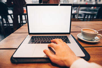 Male hand working by laptop computer with empty screen in a cafe