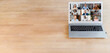 © Vadim Pastuh - A laptop with a many people profile on it on the wooden table, video call, video conference, online video meeting of multiracial team. Copy space