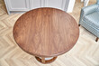 © timltv - Elegant round brown coffee table made of patterned veneer and solid walnut with acrylic part on floor in living room upper view