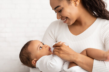 Wall Mural - Happy Black Mother Feeding Newborn Baby Giving Bottle, White Background