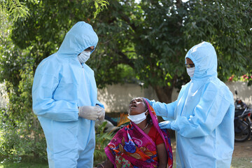 Poster - Closeup shot of two Indian doctors with medical uniforms and masks checking the covid-19 test