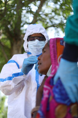 Sticker - Vertical shot of an Indian doctor with a medical uniform and mask who takes the test for a woman