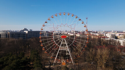 A panoramic shot of a spring city park. The Ferris wheel is visible.