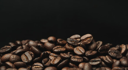 Roasted coffee beans on a black background.   