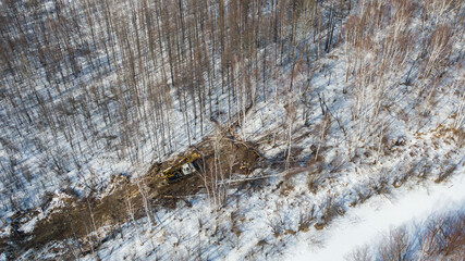 a tractor with machines in a forest in winter for cutting trees