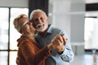 © Goran - Close-up of two unrecognizable happy mature couple dancing at home