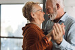 © Goran - Happy mature couple having fun while dancing at home