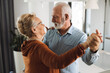 © Goran - Happy mature couple having fun while dancing at home