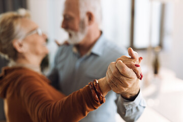 Wall Mural - Close-up of two unrecognizable happy mature couple dancing at home