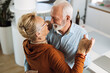 © Goran - Happy mature couple having fun while dancing at home