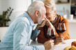 © Goran - Loving senior couple communicating while drinking wine at home
