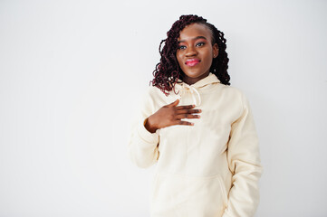 African woman in hoodie stand against white wall.