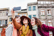 © Eva - three women sightseeing Porto views and taking picture with mobile phone. Travel and friendship concept