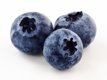 Macro Shot Of Three Blueberries Isolated On A White Background