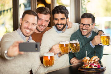 Wall Mural - Group of happy friends have a fun in beer pub