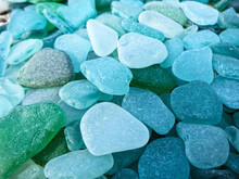 Pieces Of Glass Of Frosted Blue And Green Glass On Glass Beach Background 