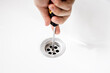 © Andrii - handyman repairing or cleaning clogged sink drain at bath. plumber service concept