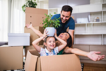 Family unpacking cardboard boxes at new home.