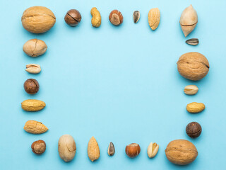 Wall Mural - Nuts of different varieties in the form of a frame on a blue background.