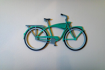 Green wooden decorative bike on a wall.